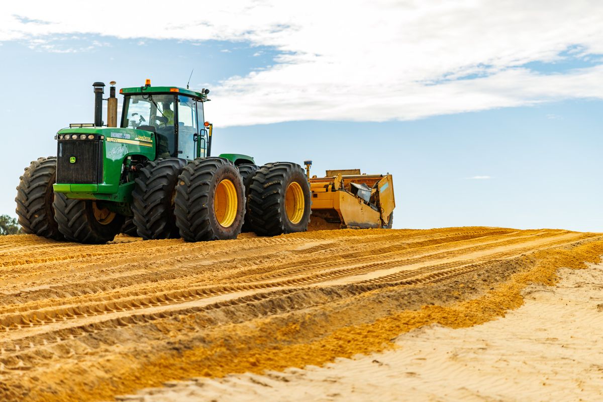 John Deere and towed scraper working